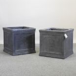 A pair of large grey garden planters,