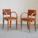 A pair of Art Deco style brown leather upholstered open armchairs