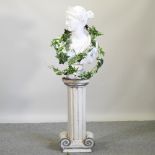 A classical style painted plaster portrait bust, on a pedestal base, in the form of a column,