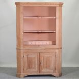 A large 19th century pine standing corner cabinet,