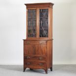 An early 20th century mahogany and crossbanded bow front cabinet bookcase,