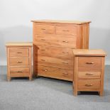An oak chest of drawers, 99cm, together with a pair of matching bedside cabinets and a mirror,