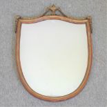 A modern gilt framed wall mirror, of shield shape, surmounted by an urn,