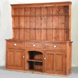 An antique pine dresser, with a plate rack and cupboards below,