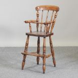 A 19th century elm seated child's high chair