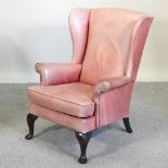 A red leather upholstered wing back armchair