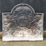 A large cast iron fire back, of arched shape, decorated in relief with a heraldic crest,