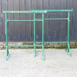 A pair of green painted adjustable scaffold stands,