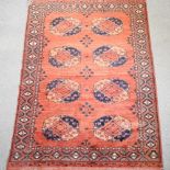 A Turkish woollen rug, with two rows of medallions, on a red ground,