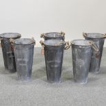 A set of six circular galvanized tall metal planters,