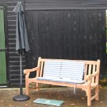 A hardwood garden bench, with blue and white striped loose cushions, and cover, 183cm,