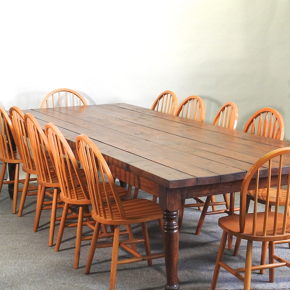 A large stained pine dining table, with a plank top, 337 x 124cm,
