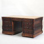 An unusual Victorian heavily carved oak partner's pedestal desk,