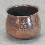 An Arts and Crafts copper studded and hammer beaten jardiniere, with relief decoration,