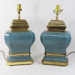 A pair of green glazed pottery table lamps, with brass mounts,