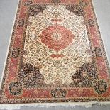 A keshan style rug, with a central medallion and foliate design, on a cream ground,