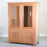 A modern light oak glazed cabinet,