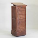 An early 20th century light oak architect's filing cabinet, with a lift-up top and tambour front,