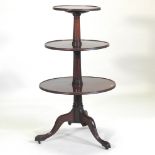 A George III mahogany three tier dumb waiter, on a tripod base,