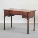 An early 20th century teak writing desk, containing three short drawers,