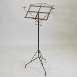 A wrought iron music stand, with candle sconces,