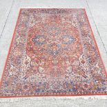 A Persian woollen carpet, on a red ground,