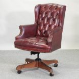 A red upholstered button back High Point swivel desk chair