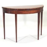 A George III mahogany half round tea table, with a hinged top, on square tapered legs,