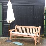 A hardwood garden bench, with cream loose cushions, and cover, 183cm,
