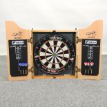 A Phil Taylor dart board in cabinet,