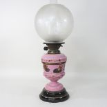 A 19th century oil lamp, with a pink opaline reservoir, and an etched glass shade,