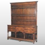 An 18th century style oak dresser, the boarded plate rack, over arrangement of short drawers,