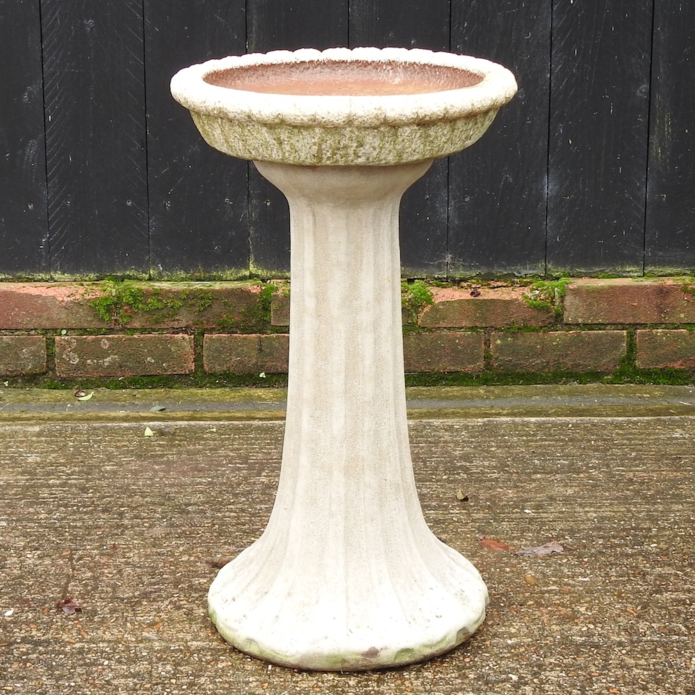 A reconstituted stone bird bath,