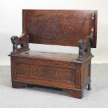 An early 20th century carved oak monk's bench,