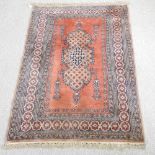 A Persian Tabriz rug, with a central medallion, on a red ground,