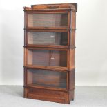 An early 20th century Globe Wernicke oak graduated four tier glazed bookcase, on a plinth base,