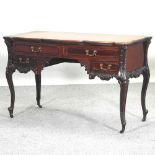An Edwardian carved writing desk, with a leather inset top, on cabriole legs,