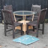 A circular woven garden table, with a glass top, 95cm diameter,