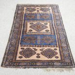 A Turkish woollen rug, with two rows of medallions, on a blue ground,