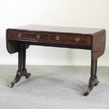 A Regency mahogany sofa table, with a hinged rectangular top, on a splayed base,