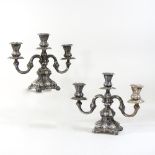 A pair of early 20th century Danish silver two branch table candelabra, each on a scrolled base,