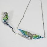 A white metal and enamel brooch, in the form of a parrot,