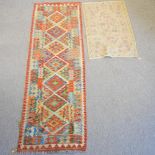 A kelim runner, with seven central medallions, on an orange ground, 250 x 82cm,
