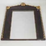 An early 19th century rosewood and parcel gilt framed wall mirror, surmounted by shells and scrolls,