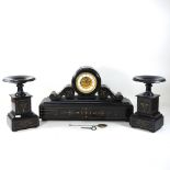 A 19th century black slate three piece clock garniture, the drum movement striking on a bell,