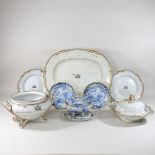 A 19th century white glazed part dinner service, each piece bearing a family crest,
