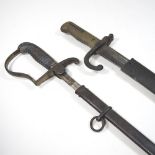 An early 20th century bayonet, having a steel blade and brass grip, in an iron scabbard,