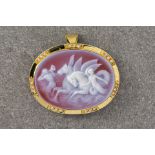 A glass cameo brooch featuring the image of Poseidon, in a yellow gold setting and featuring trilogy