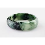 A contemporary jade bangle, of dark green and white marbled colouring and with a diameter of