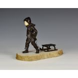 An Art Deco bronze and ivory figure of a boy with a toboggan, 1920s, with dark brown patination, the